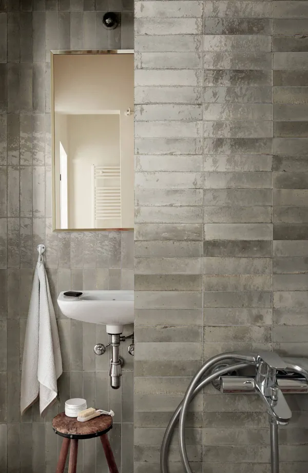 Baño con azulejos efecto barro, colección Lume de Marazzi