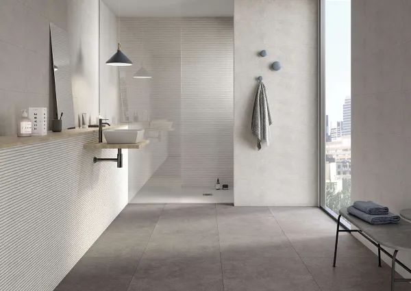 Baño con azulejos efecto cemento en tonos neutros, colección Clunia de Durstone