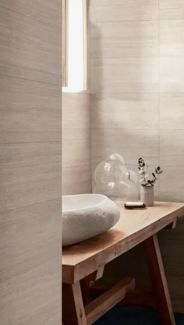 Baño con azulejos efecto mármol en tonos cálidos, colección Travertino de Marazzi