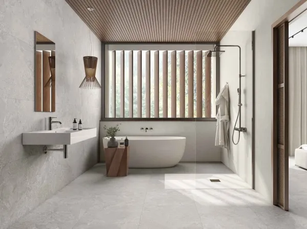 Baño con azulejos efecto piedra en tonos neutros, colección Avalon de Roca