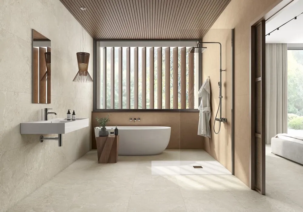 Baño con azulejos efecto piedra en tonos cálidos, colección Avalon de Roca