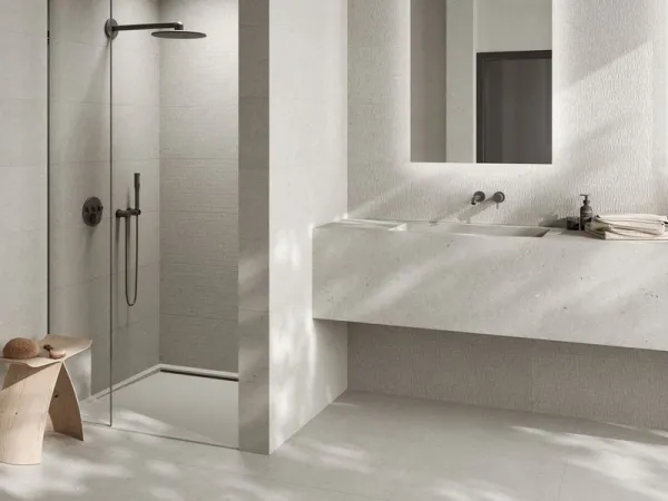 Baño con azulejos efecto piedra en tonos neutros, colección Somport de Durstone
