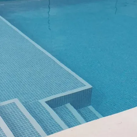 Piscina con azulejos efecto monocolor en tonos fríos, colección Genuine de Squamers