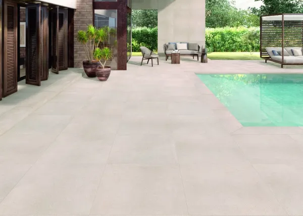 Piscina con azulejos efecto piedra en tonos neutros, colección Alma de Natucer
