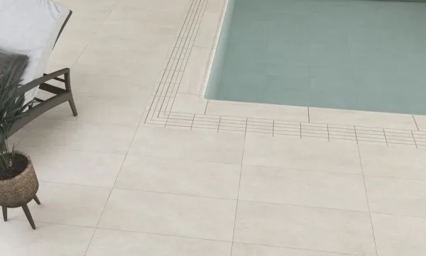 Piscina con azulejos efecto piedra en tonos neutros, colección Andratx de Mikonos