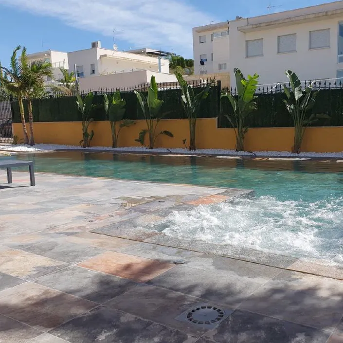 Piscina con azulejos efecto piedra en tonos fríos, colección Aspen de Mikonos