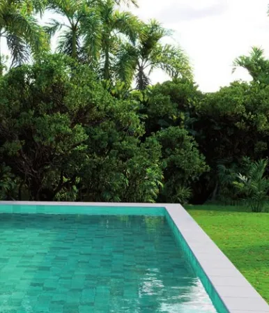 Piscina con azulejos efecto piedra en tonos fríos, colección Bali de Mayor