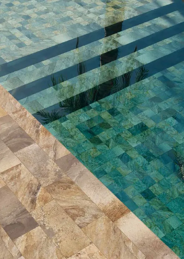 Piscina con azulejos efecto piedra en tonos fríos, colección Cupira de Mayor