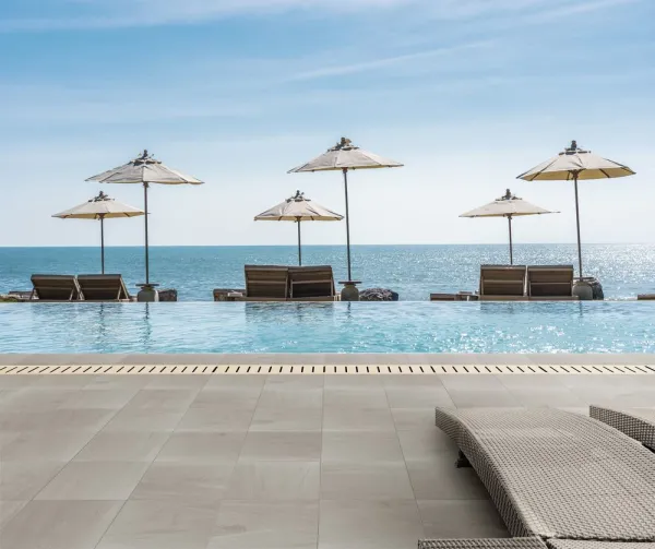 Piscina con azulejos efecto piedra en tonos fríos, colección Grain de Venatto