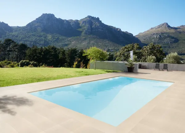 Piscina con azulejos efecto piedra en tonos fríos, colección Grain de Venatto
