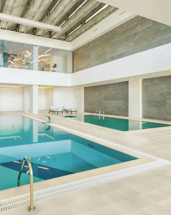 Piscina con azulejos efecto piedra en tonos fríos, colección Grain de Venatto