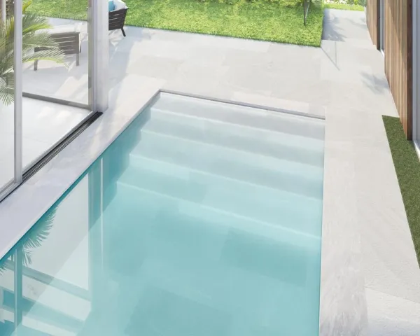 Piscina con azulejos efecto piedra en tonos fríos, colección Pietrasanta de Dune