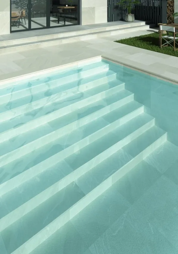Piscina con azulejos efecto piedra en tonos fríos, colección Pietrasanta de Dune
