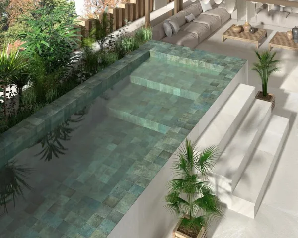 Piscina con azulejos efecto piedra en tonos fríos, colección Pietrasanta de Dune