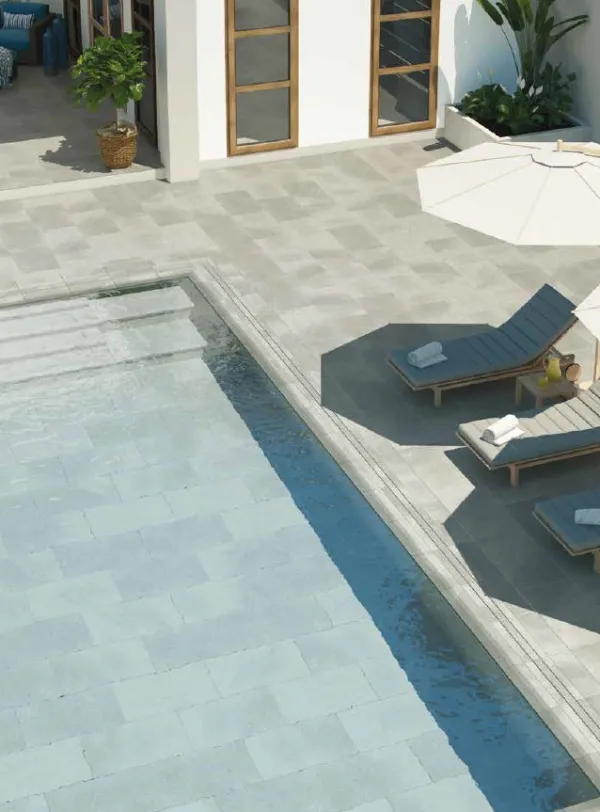 Piscina con azulejos efecto piedra en tonos fríos, colección Stromboli de Mayor