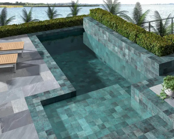 Piscina con azulejos efecto piedra en tonos fríos, colección Tahiti de Dune
