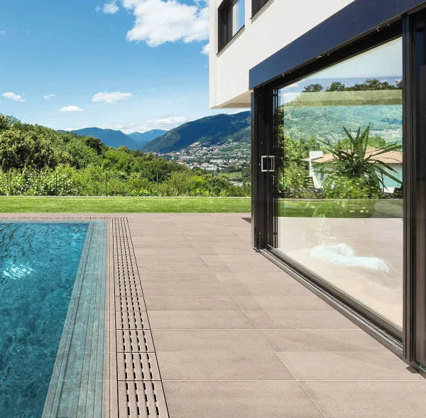 Piscina con azulejos efecto piedra en tonos fríos, colección Tucson de Natucer