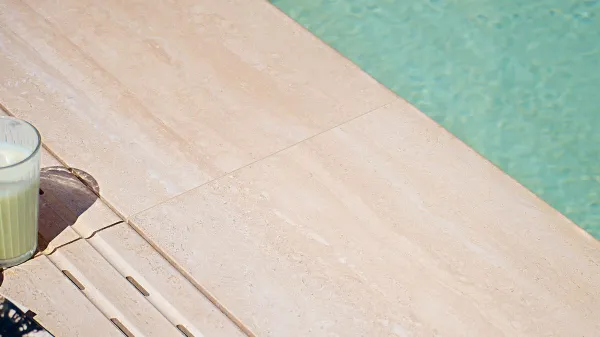 Piscina con azulejos efecto piedra en tonos cálidos, colección Veincut de Mayor