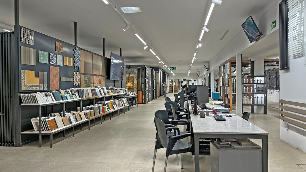 Pasillo de la exposición de cerámica con muestrarios y mesas de atención en la sede central de Ferrolan